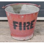 Vintage metal fire bucket with swing-over handle painted red with 'FIRE' in black, 29cm tall with
