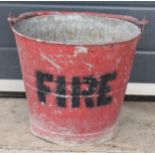 Vintage metal fire bucket with swing-over handle painted red with 'FIRE' in black, 30cm tall with