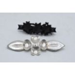 A pair of vintage brooches to include white metal stylised floral brooch and a vulcanite ivy