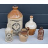 A collection of stoneware bottles and flagons to include Herbert Lees, Findlater and Mackie together