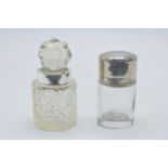 Silver lidded / hinged oval scent bottle together with silver rimmed scent bottle (2). 8.5cm tall.