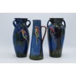 A trio of Longpark Torquay Ware vases with each decorated with a parrot amongst tree branches, one