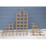 A trio of vintage bent metal wine bottle holders in the form of an arched example and 2 small items,