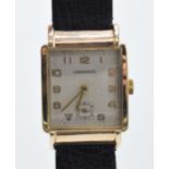 9ct gold Garrard wristwatch on black leather strap, heavy case, does wind and tick though does