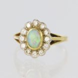 18ct yellow gold cluster ring featuring a central oval opal measuring approx. 7mm x 5mm,
