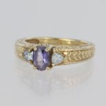 9ct yellow gold ring set with an oval tanzanite measuring approx. 5mm x 4mm, with a trillion cut