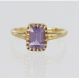 18ct yellow gold ring set with a single step cut amethyst measuring approx. 8mm x 6mm, finger size