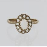 9ct yellow gold cluster ring set with an oval opal cabochon measuring approx. 6mm x 5mm,