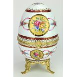 Faberge-inspired decorative porcelain egg. With a metal gilt clasp and on a three legged base.