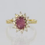 18ct yellow gold ring featuring a central oval pink sapphire measuring approx. 7mm x 5mm, surrounded