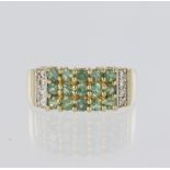 14ct yellow gold band ring set with five rows of three green stones and highlighted by eight diamond