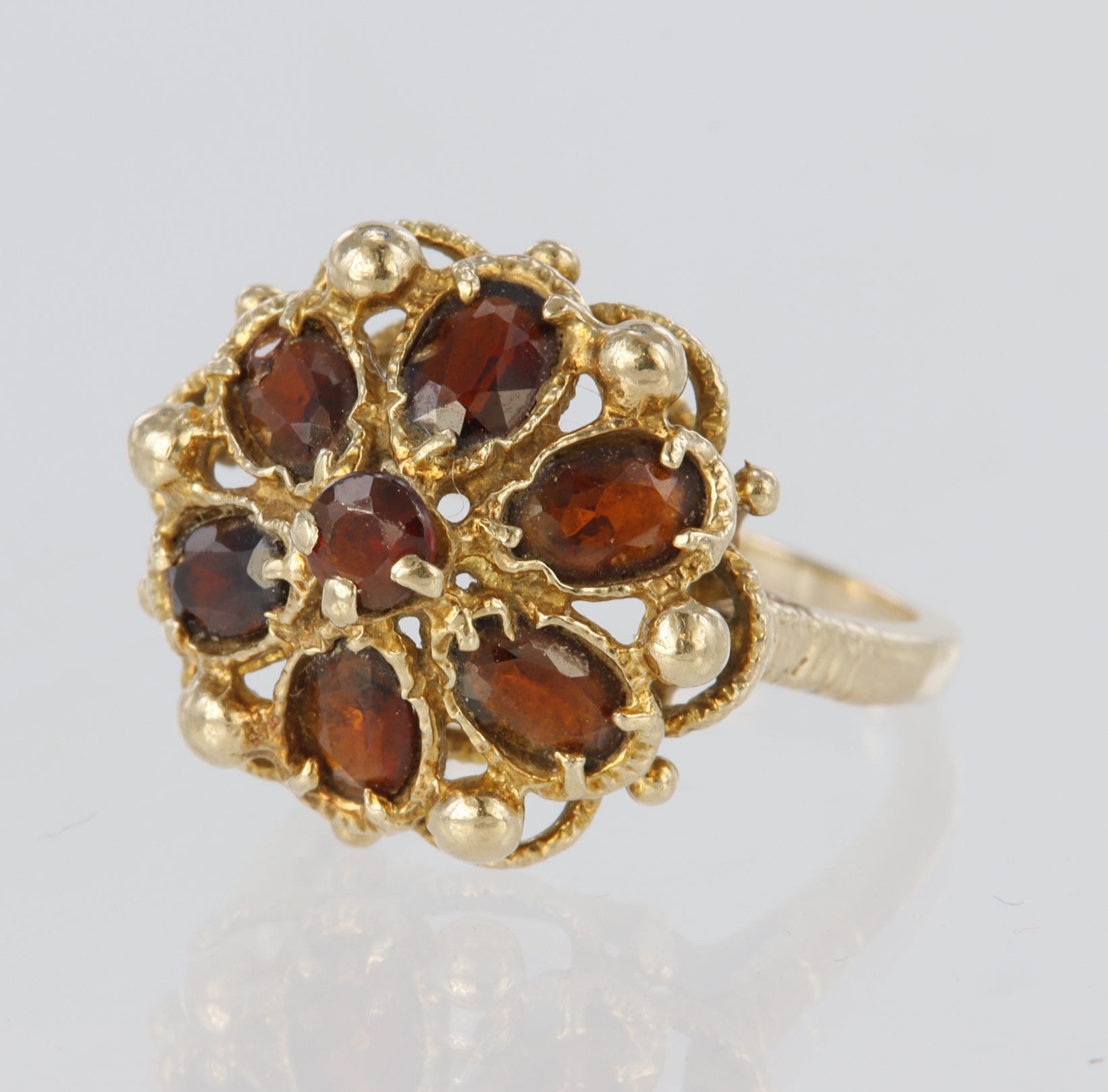 9ct yellow gold dress ring set with a central 2mm round garnet surrounded by six pear shaped garnets