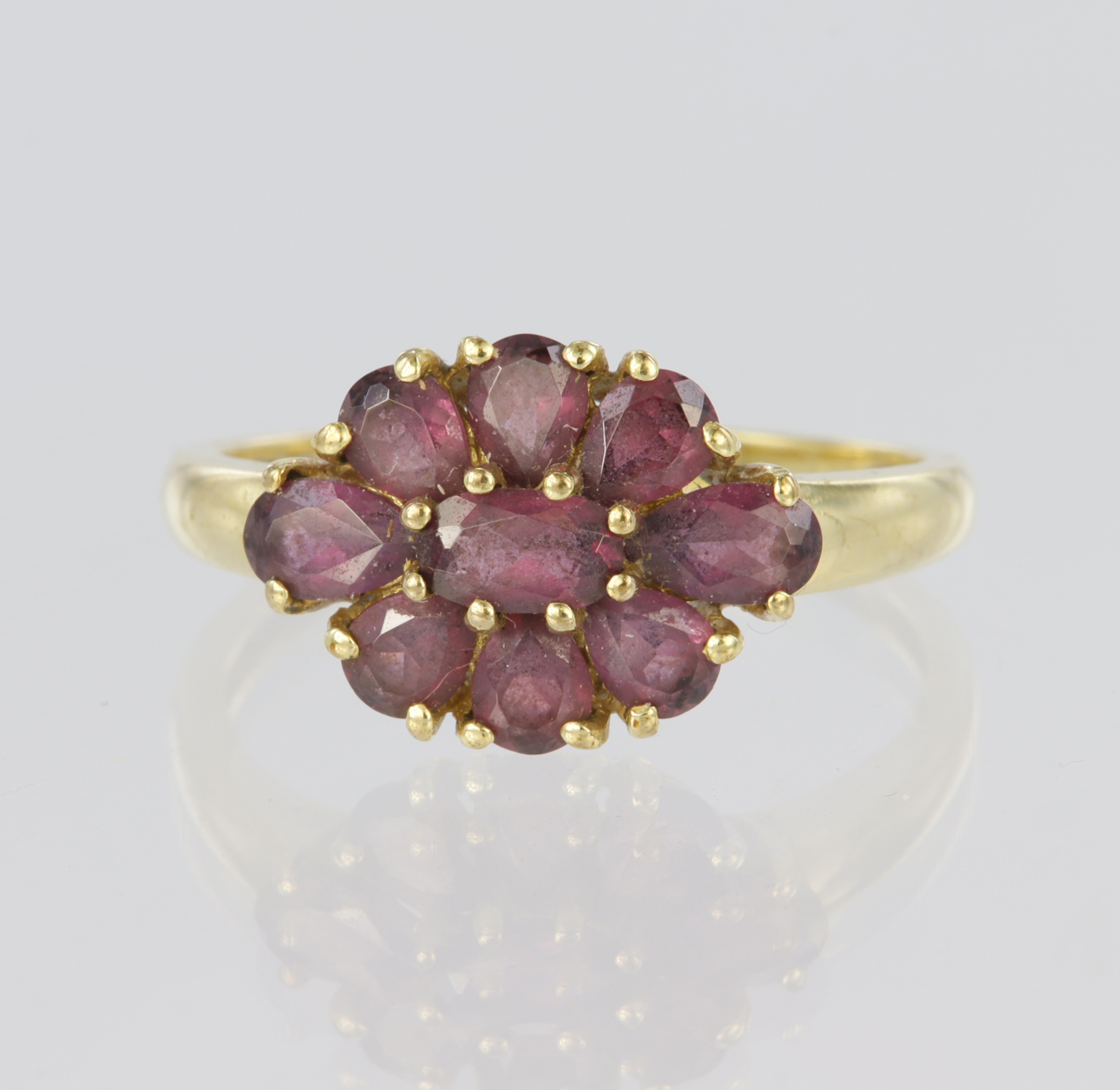 9ct yellow gold cluster ring set with nine almandine garnets, an oval centre stone surrounded by