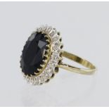 9ct yellow gold cluster ring set with a central oval sapphire measuring approx. 14mm x 10mm,