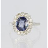 Platinum ring featuring a central oval sapphire measuring approx. 8mm x 7mm in a rub over collet,