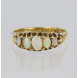 18ct yellow gold ring set with five graduated oval opals in a carved head design, finger size J,