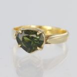 Yellow metal ring set with a heart shaped green tourmaline measuring approx. 10mm x 8mm in a four