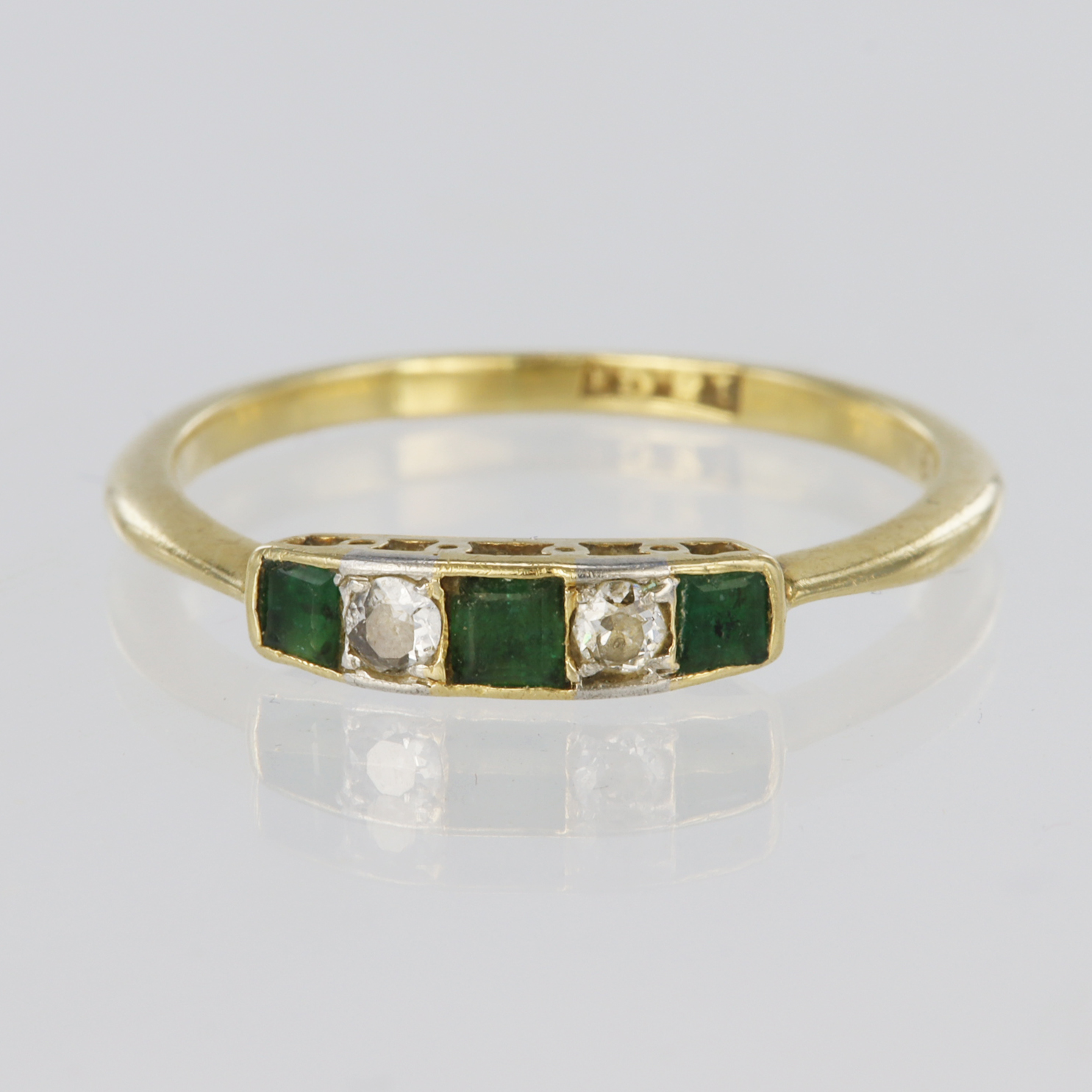 18ct yellow gold ring set with three graduated princess cut emeralds spaced by two round brilliant