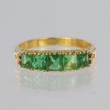 22ct yellow gold ring set with five graduated princess cut green stones