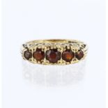 9ct yellow gold carved head ring set with five graduated round garnets ranging from 4.5mm to 2.5mm