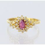 22ct yellow gold ring set with a central oval ruby measuring approx. 6mm x 4mm, surrounded by twelve