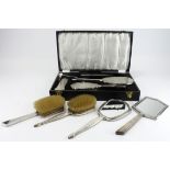 Silver. A cased four piece dressing table set, comprising two brushes, comb and hand mirror,