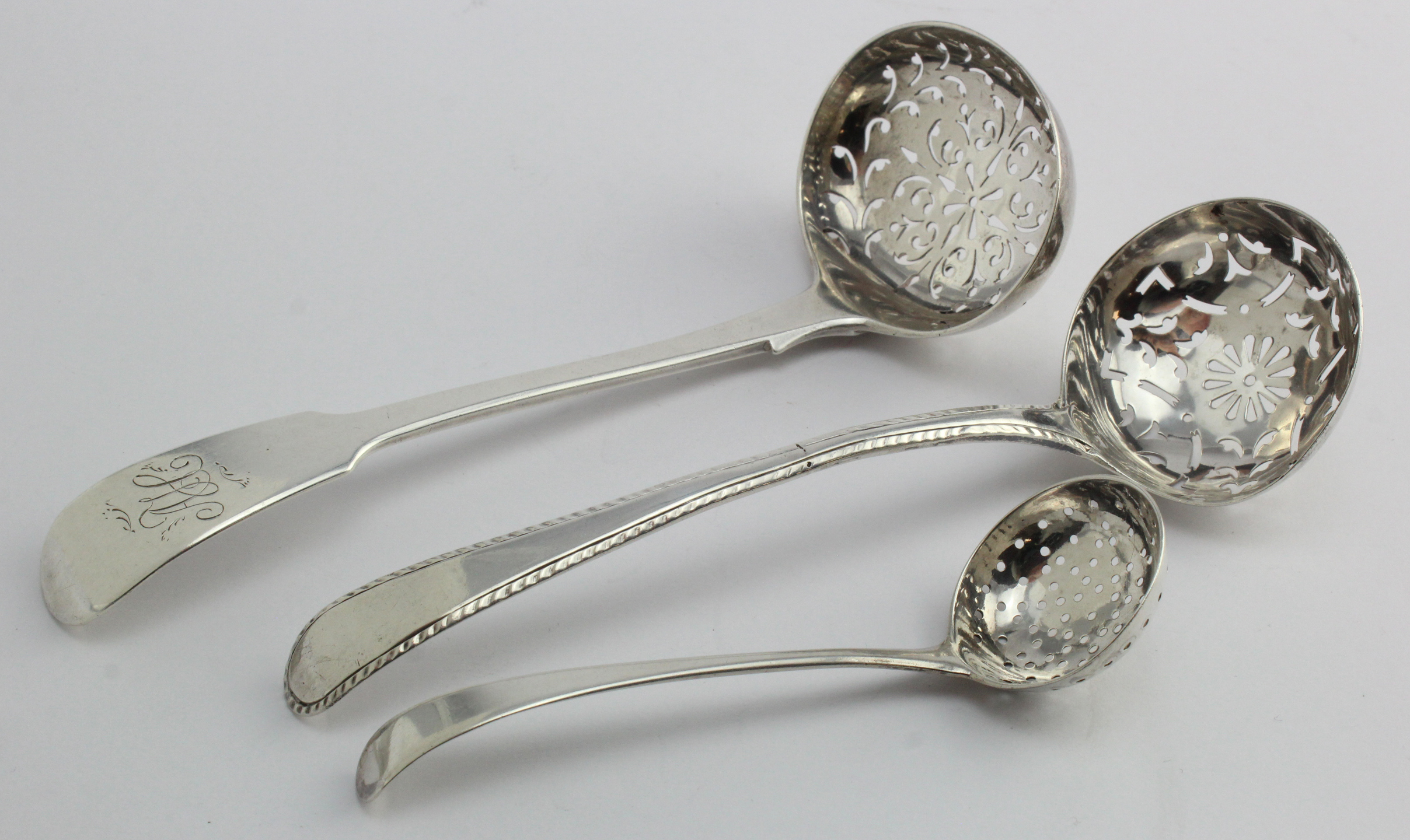 Two George III silver sugar sifters c1780/1790 plus one Victorian silver fiddle pattern sugar