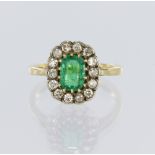 18ct yellow gold cluster ring featuring a multi claw set central octagonal step cut emerald