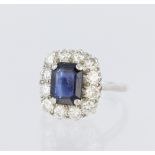 Platinum cluster ring set with a central rectangular step cut sapphire measuring approx. 9mm x