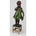 Bronze cold painted figure of a young girl standing upon a stool. Height measures approx 36.5cm.