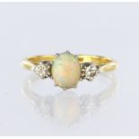 18ct yellow gold and platinum three stone ring featuring a central oval opal cabochon measuring