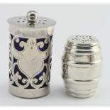 Two attractive silver pepper pots, one Art Nouveau style and one in the shape of a barrel - they are