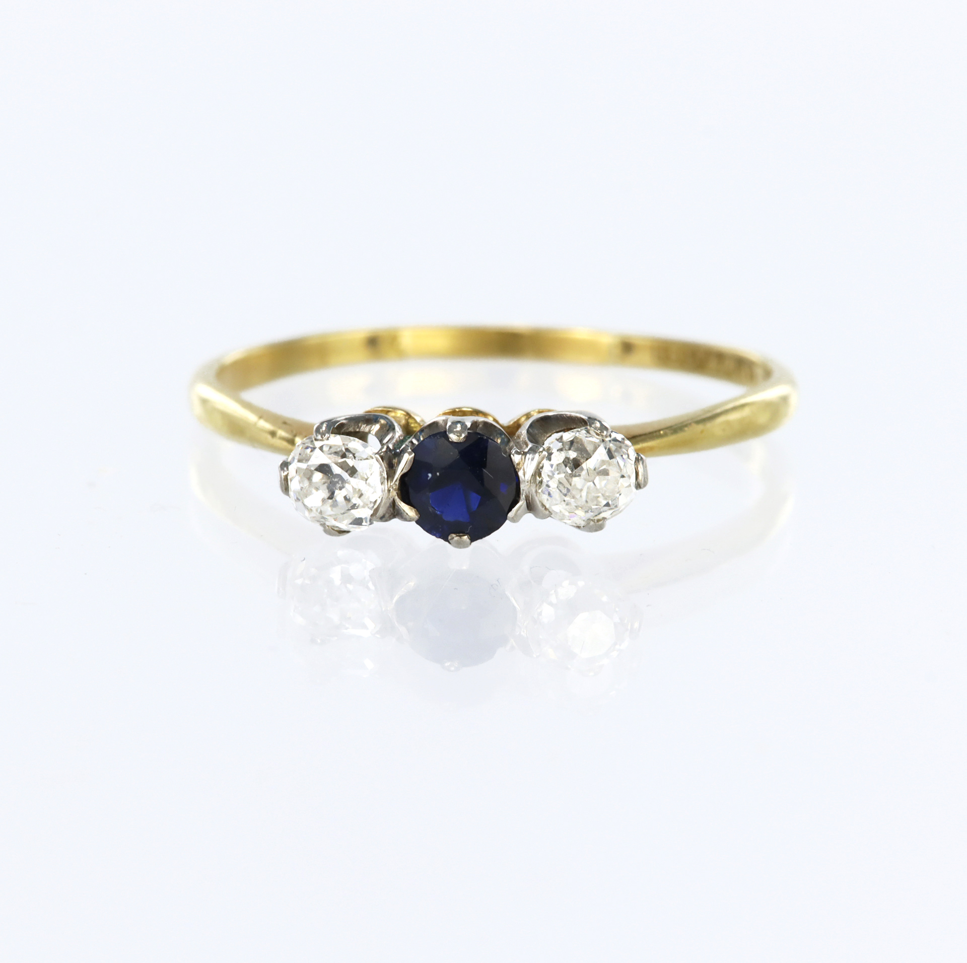 18ct yellow gold and platinum three stone ring set with a central round sapphire measuring approx.