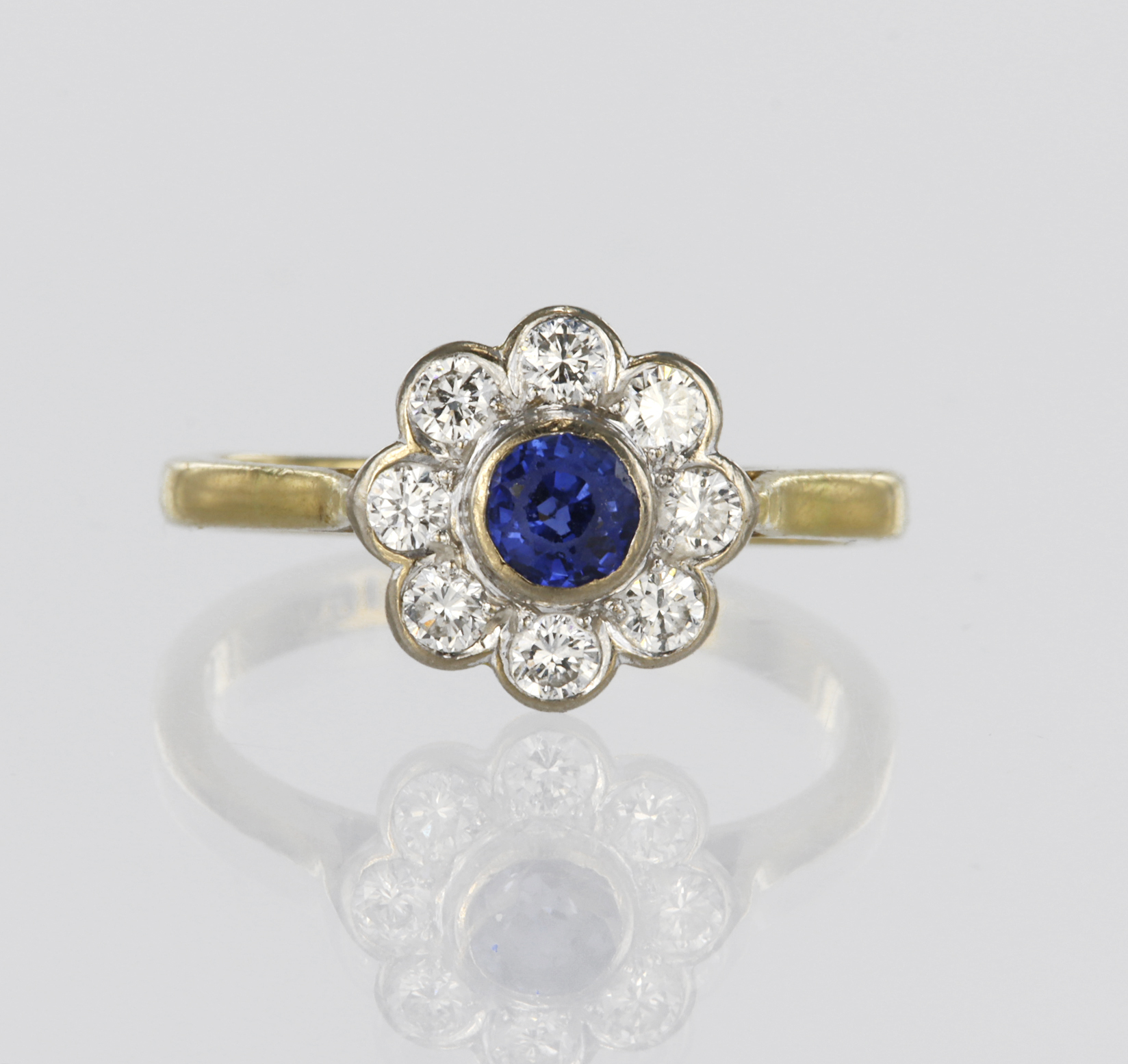 18ct yellow gold daisy cluster ring featuring a central round sapphire measuring approx. 4mm