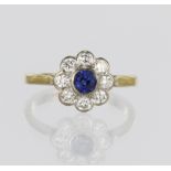 18ct yellow gold daisy cluster ring featuring a central round sapphire measuring approx. 4mm
