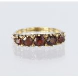 9ct yellow gold carved head ring set with five graduated round garnets ranging from 4mm x 2,5mm