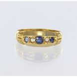 18ct yellow gold boat shaped ring set with three graduated round sapphires, and two round old cut
