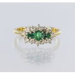 18ct yellow gold triple cluster ring featuring three rectangular step cut emeralds, the centre