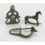 Antiquity. Three ancient bronze brooches, including one depicting a horse, largest length 45mm