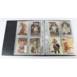 Novelty postcards collection housed in a modern album, including fantasy heads and postcards with