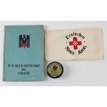 German 1942 Red Cross medical book with German Red Cross arm band and a jar of ointment.