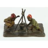 Cold painted bronze depicting two Middle-Eastern boys seated around a fire with a hanging cooking