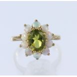 9ct yellow gold cluster ring set with a central oval peridot measuring approx. 8mm x 6m surrounded
