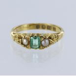 18ct yellow gold ring set with a central emerald measuring approx. 4.5mm x 3.5mm, with a seed