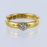 22ct yellow gold band ring with a white gold collet holding a single cushion shaped old cut