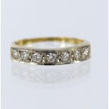 18ct yellow gold diamond ring, set with seven round brilliant cut diamonds in a grain setting, total