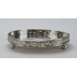 Chinese silver small galleried tray/waiter, flat chased with dragons, stands on three ball feet,