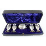 Boxed set of four silver peppers (one lid not hallmarked but looks right) plus a silver mustard