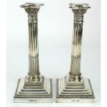 Silver pair of corinthium pillar candlesticks, hallmarked 'Walker & Hall, Chester 1906', weighted