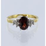 18ct yellow gold ring featuring an oval garnet measuring approx. 8mm x 6mm, with a trefoil of